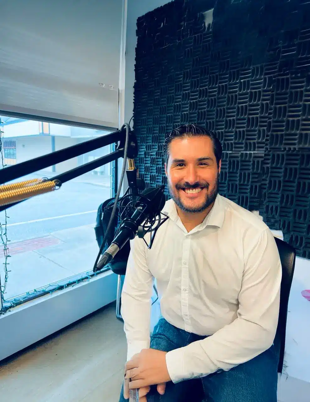 Junior Achievement leader featured in a radio studio during a community spotlight segment